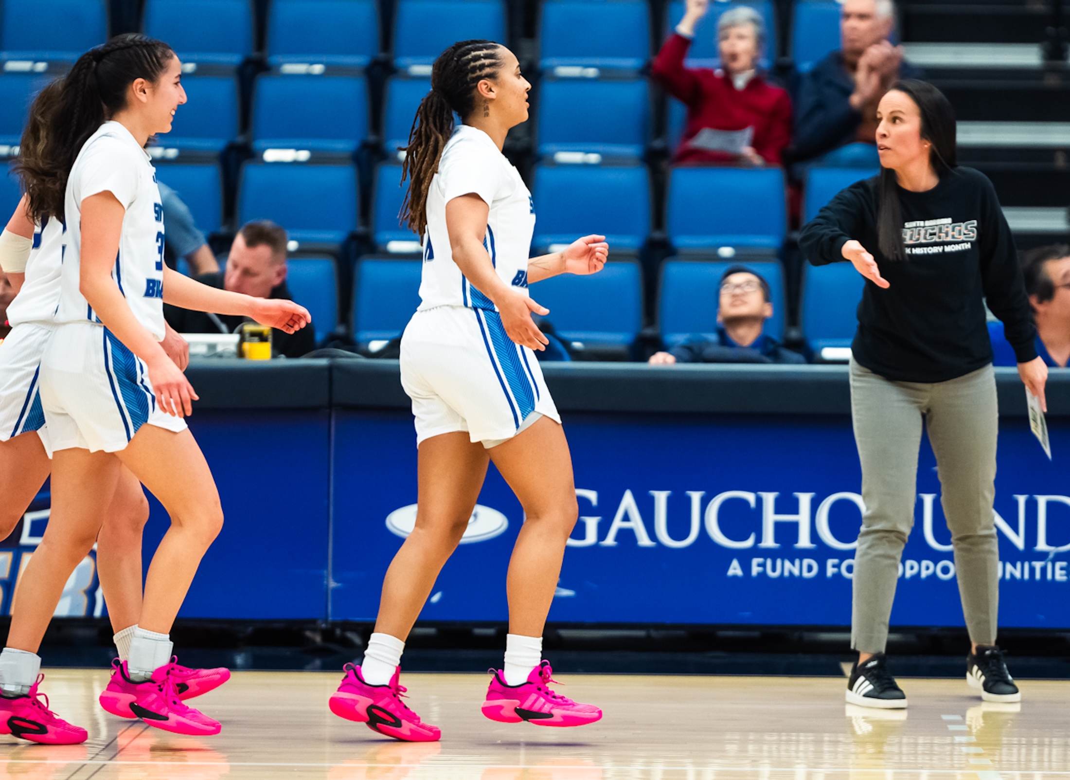 UCSB women's basketball coach Renee Jimenez reaches out to slap Anya Choice's hand after the senior guard beat the first-quarter buzzer with a three-pointer during the Gauchos' 62-52 win over UC Irvine on Thursday at the Thunderdome.