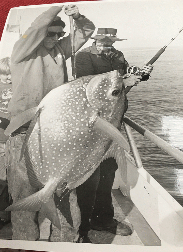 A black and white photo of David Bacon in his 20s with an 80-lb. opah he caught offshore from Morro Bay while fishing for albacore. (Courtesy photo)