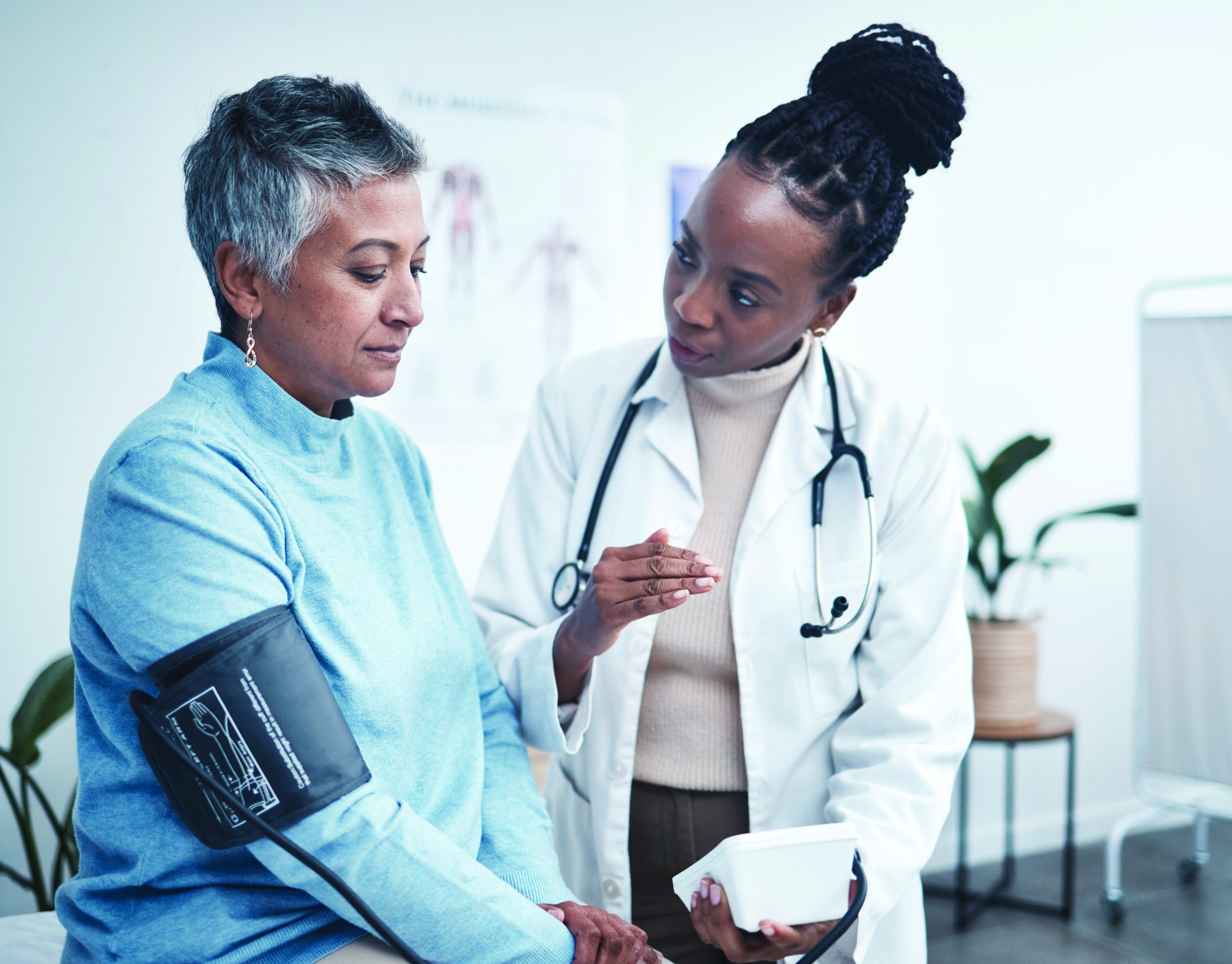 doctor and senior patient with blood pressure reading for wellness, advice and conversation.