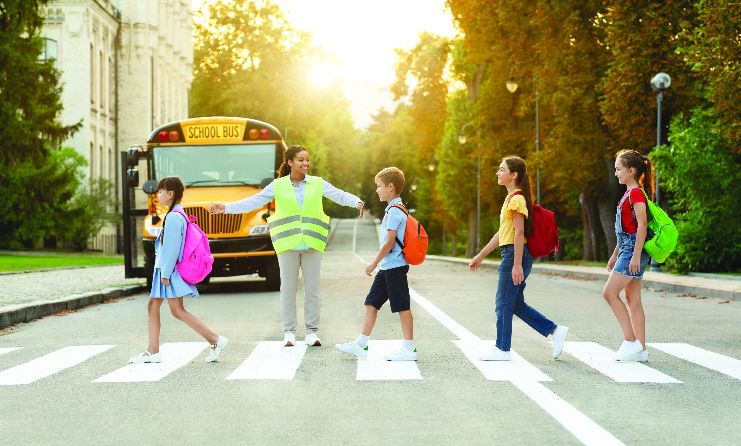 Group of children passing crosswalk on their way to school bus,