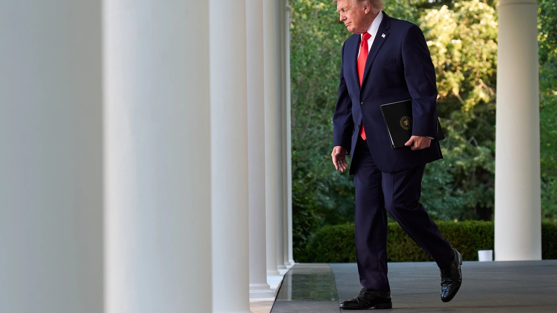 President Donald Trump walks through the Colonnade on his was to speak during a Rose Garden Club dinner with U.S. farmers