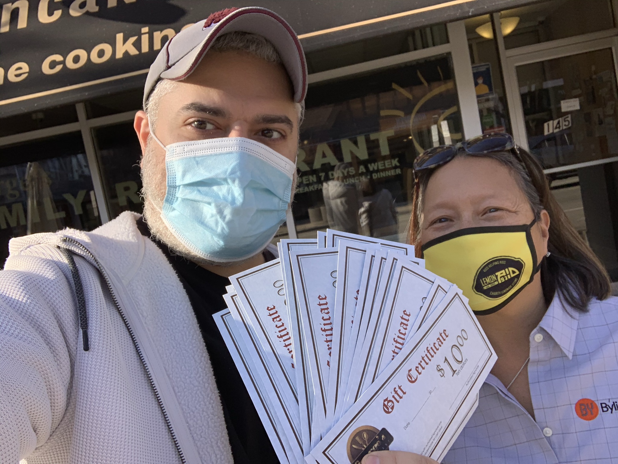 Saki Konstantos of George's Family Restaurant shows off gift certificates purchased by Susie Goldschmidt of Byline Bank.