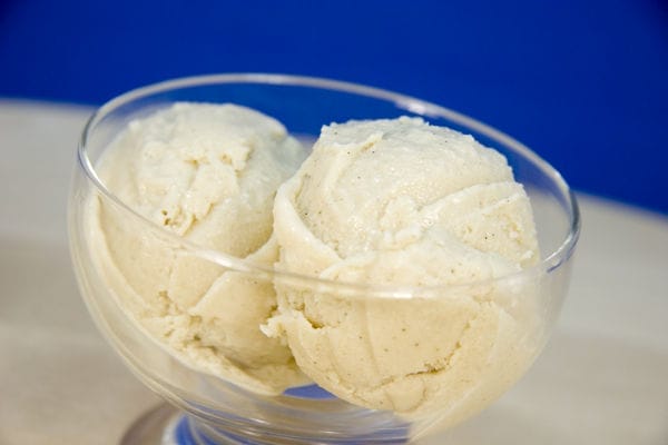 Scoops of creamy vegan coconut ice cream, made with tofu, served in a bowl with a spoon, ready to enjoy.