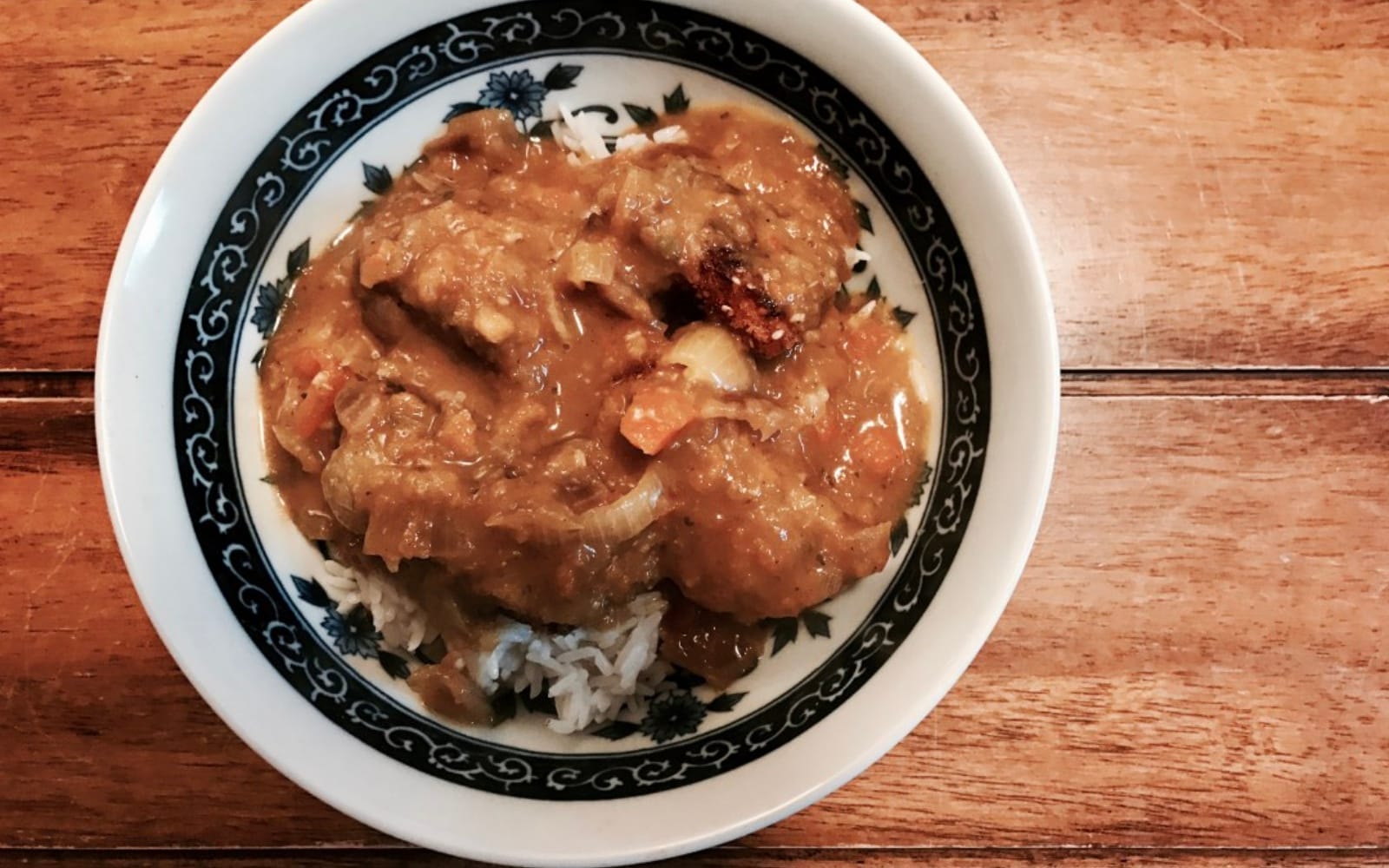 Crispy, golden-brown sweet potato katsu coated in sesame seeds, served with a rich, chunky vegetable curry sauce over white rice.