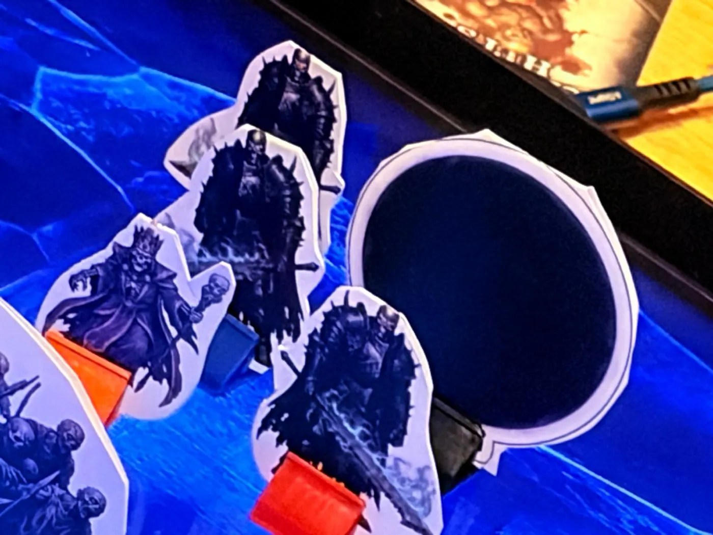 Paper standees of Acererak and his three armoured guards on the blue map screen, beside a round black standee for the sphere of annihilation.