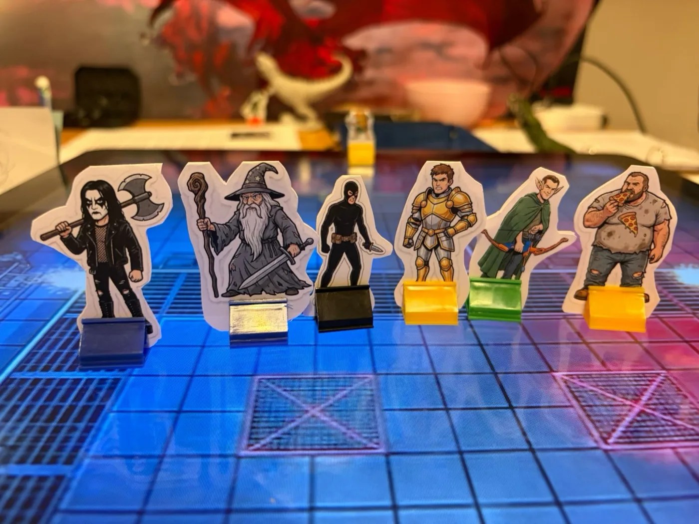 Cartoon standees of Team Rules Lawyer: a metal fan with an axe, a wizard, a ninja, a knight, an elf archer and a man eating pizza.