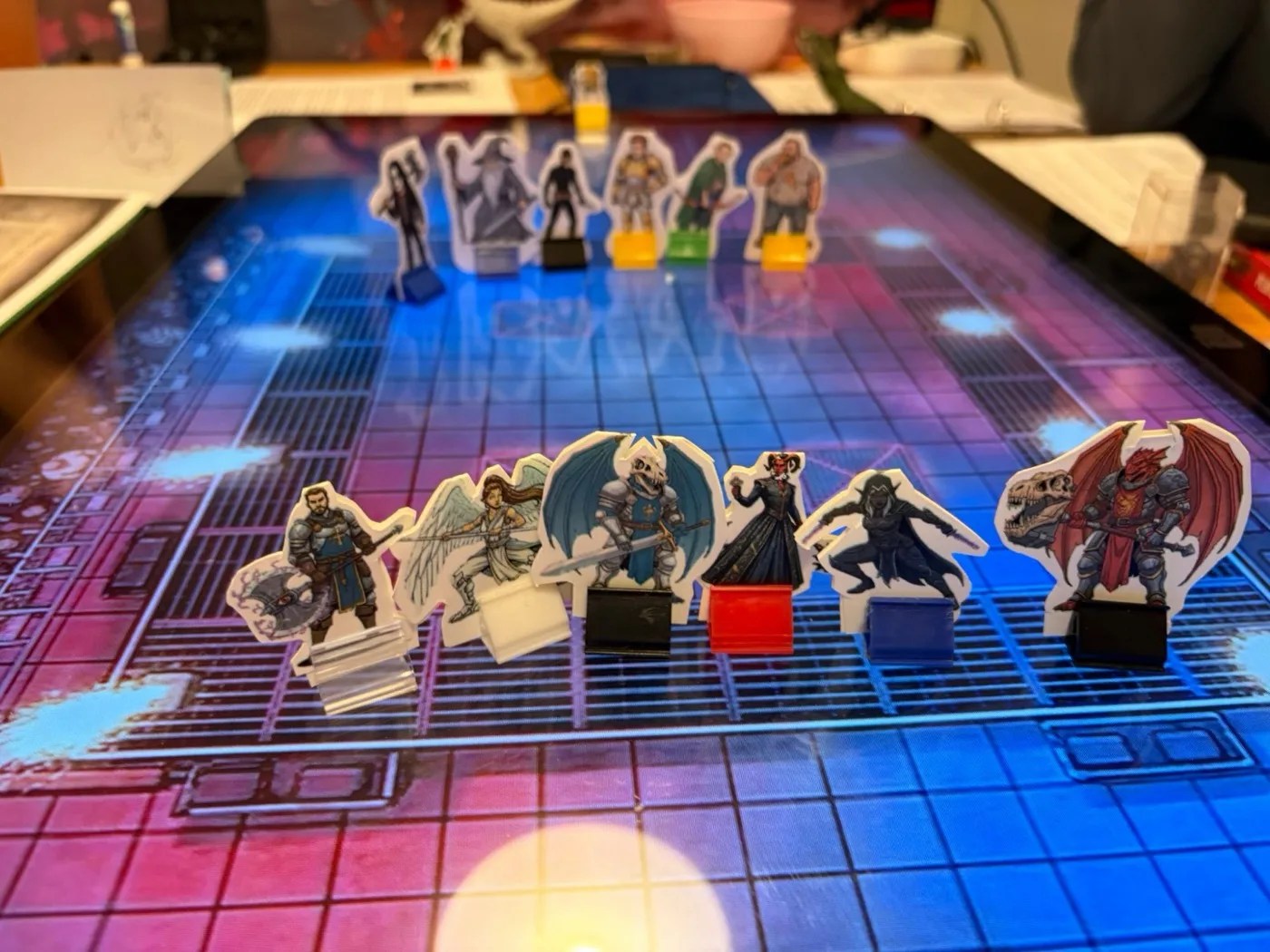 Two rows of paper standees on a neon grid map: the party in front, Team Rules Lawyer behind.
