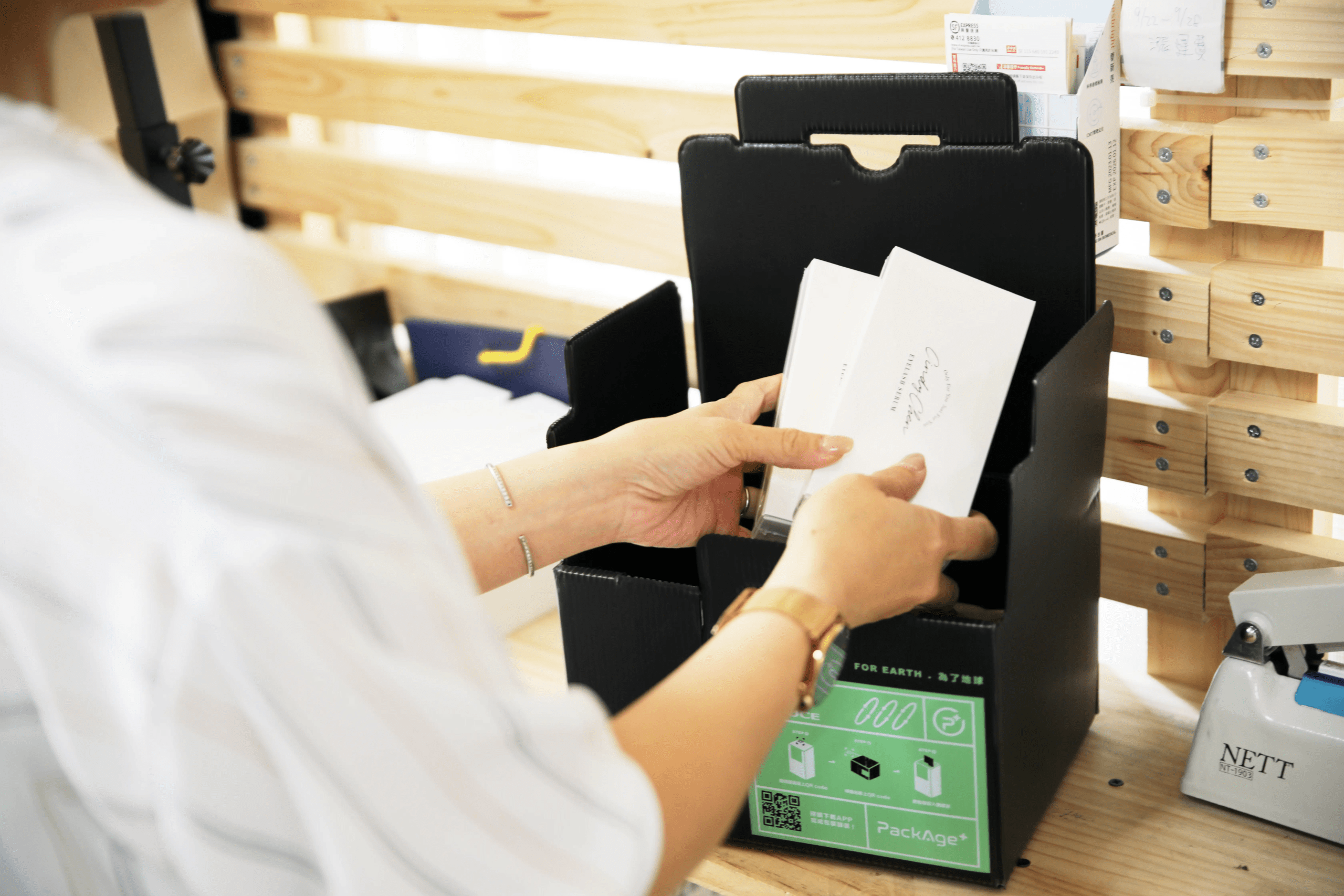 包裝過程 CindyChen工作夥伴將盒裝睫毛滋養液放入配客嘉黑色循環包裝中