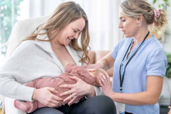 mom nursing baby with nurse's help