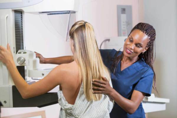 nurse helping patient doing a mammogram