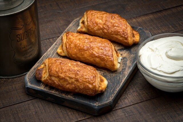 A slightly sweetened dough is rolled around a cheddar and onion filling, then baked until golden brown for these rolls. Cheese Roll Porto S Bakery