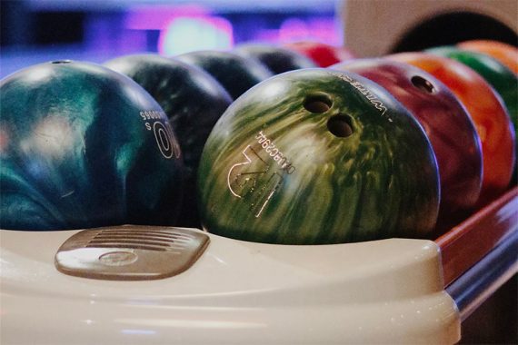 Bowling balls in a rack in a bowling alley Bowling balls in a rack in a bowling alley