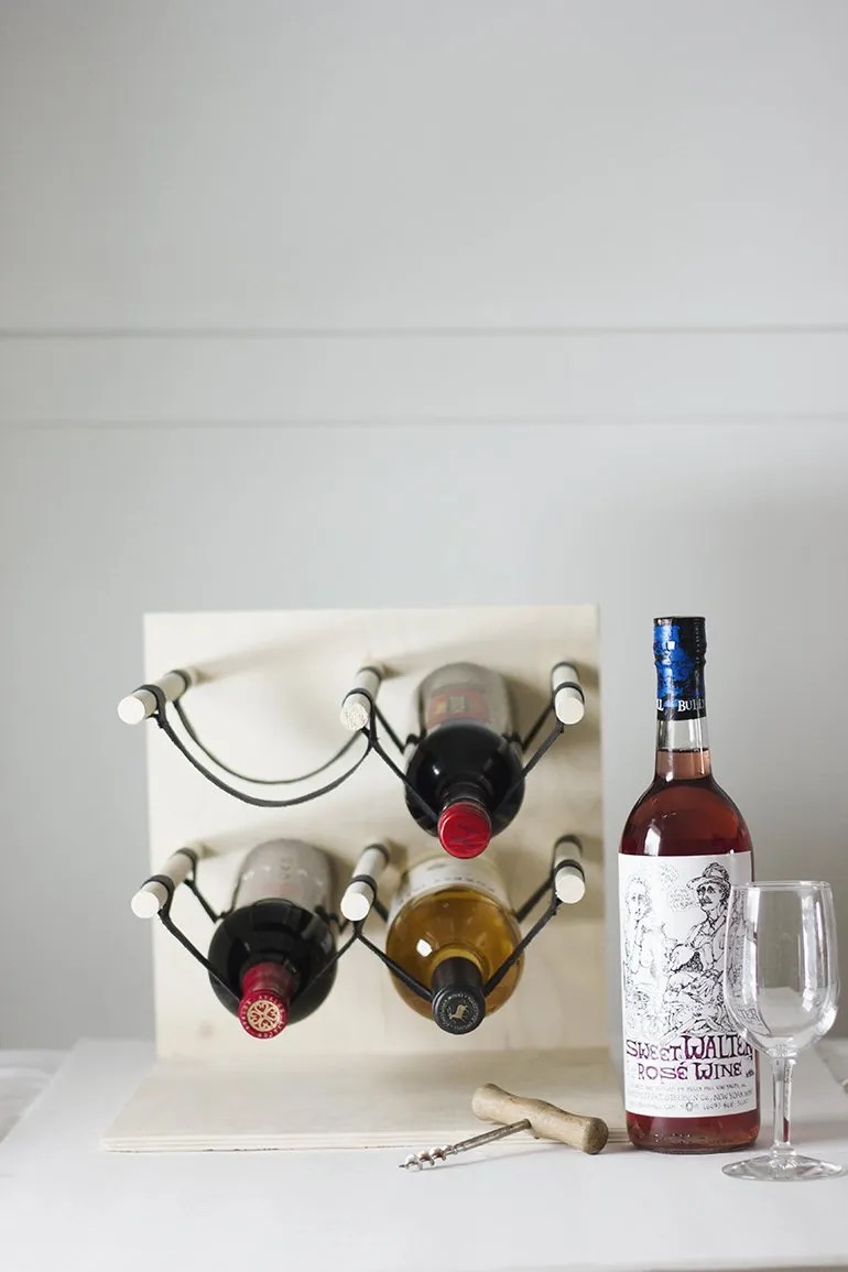A rope wine rack and wine bottle.