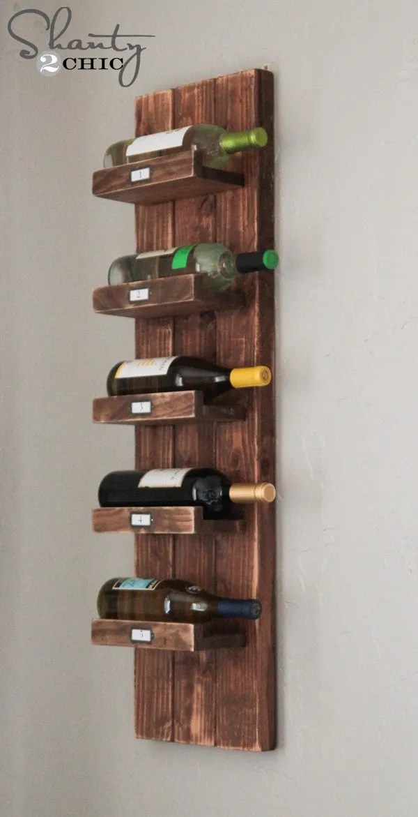A vertical wooden wine rack holding five wine bottles.