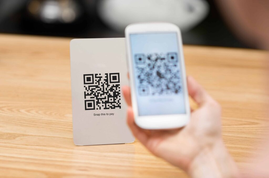 Close up of customer hand making payment through smart phone and scan code