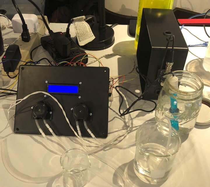 water pump and pH equipment with hoses and glass beakers sprawled about