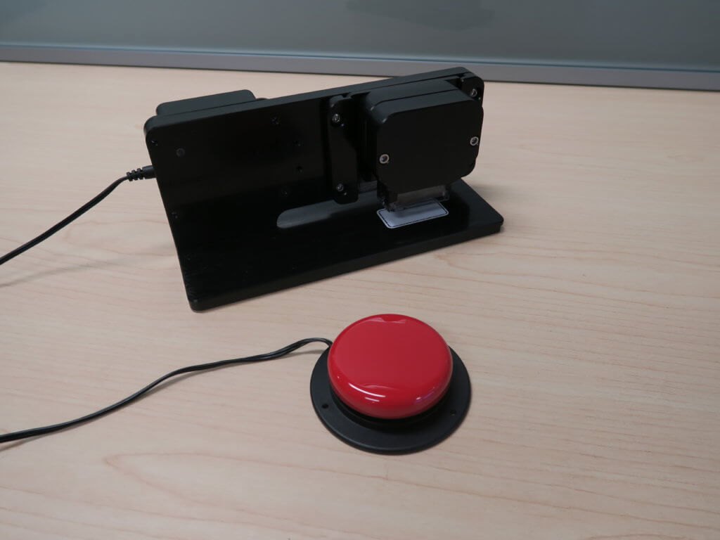 Big red button with wire attached to desktop stamping mechanism