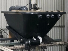 wheelbarrow modified into tub for swarf filtering, many PVC tubes extend out of wheel barrow