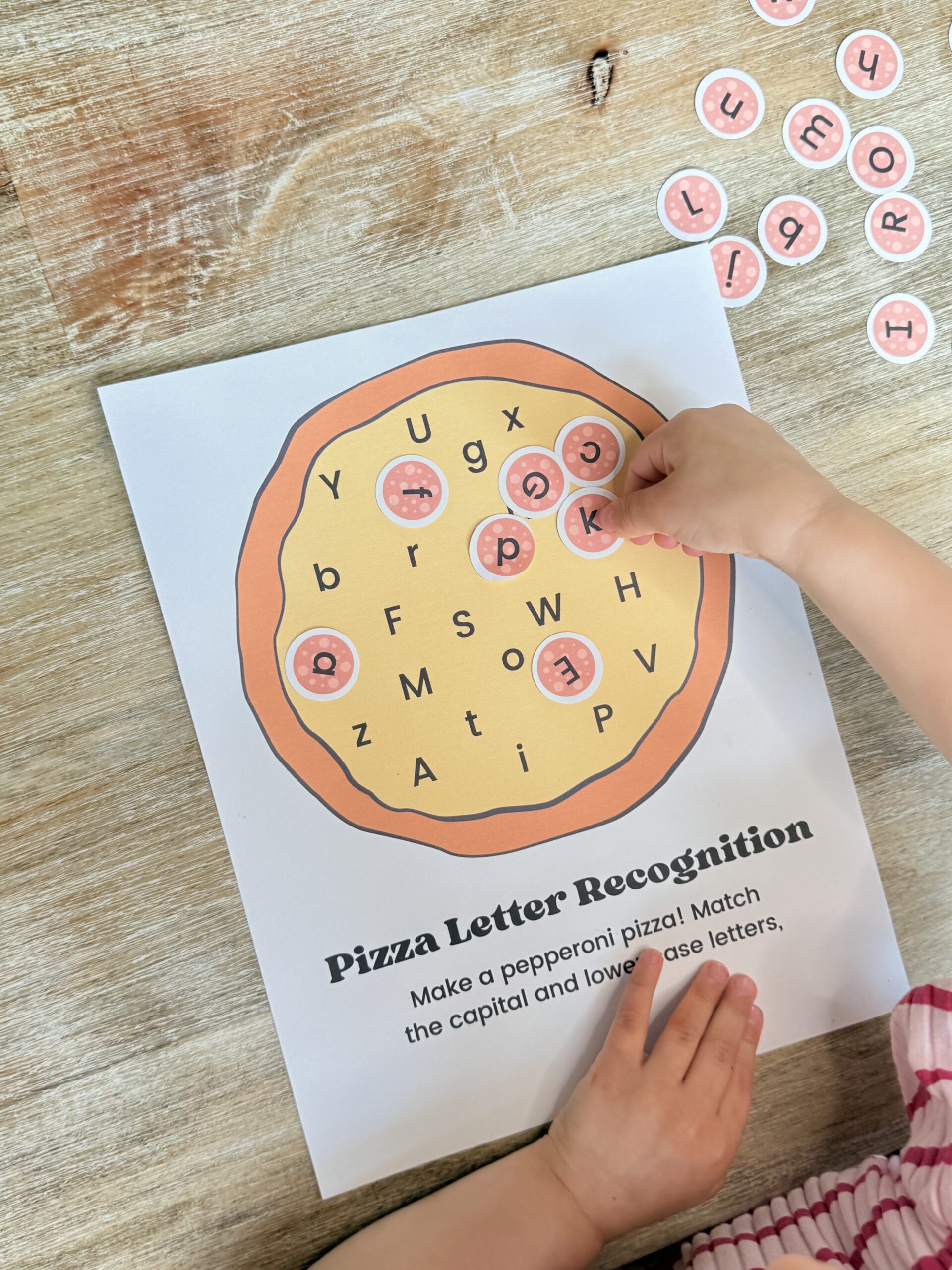 Fun pizza-themed letter recognition activity for toddlers and preschoolers! Teach upper and lower case letters with free printables and sensory play ideas.