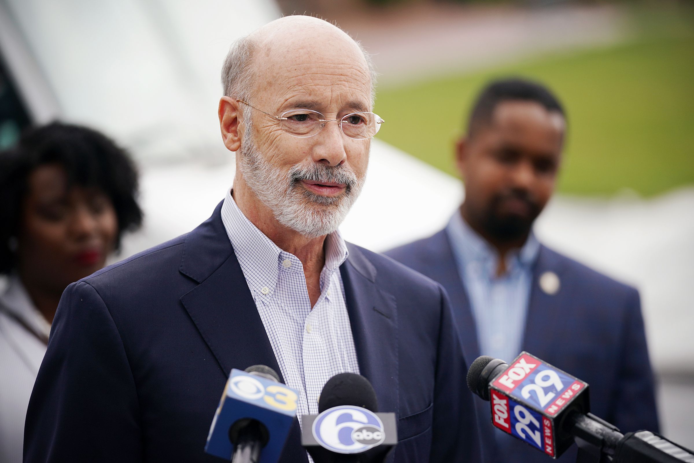 Gov. Tom Wolf speaks in fornt of microphones from various news outlets.