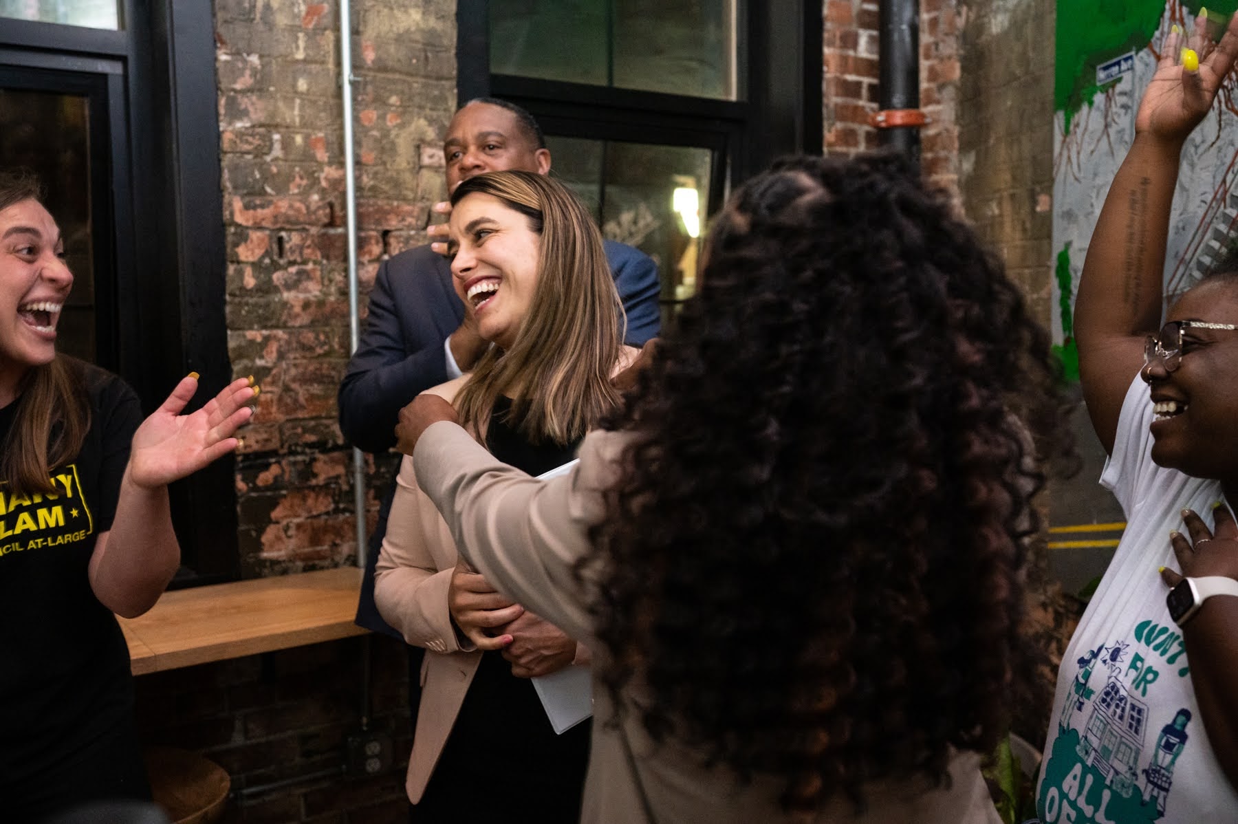 From left, Bethany Hallam, incumbent Allegheny County councilperson at large, Pittsburgh Mayor Ed Gainey, and U.S. Rep. Summer Lee, front, celebrate with Sara Innamorato, center, a state representative running for county executive, on Tuesday, May 16, 2023, as she arrives at her election party at Trace Brewing in Bloomfield. (Photo by Stephanie Strasburg/PublicSource)