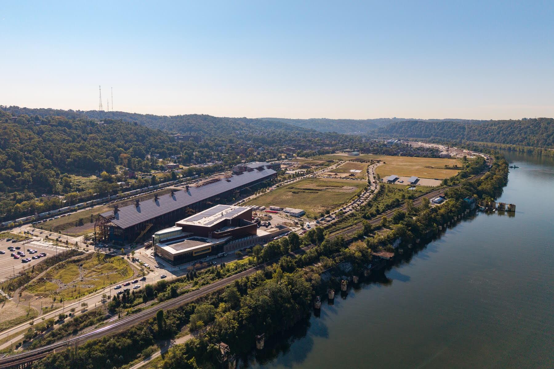 Aerial view of a large industrial complex in Hazelwood, surrounded by greenery and a river on the right side.