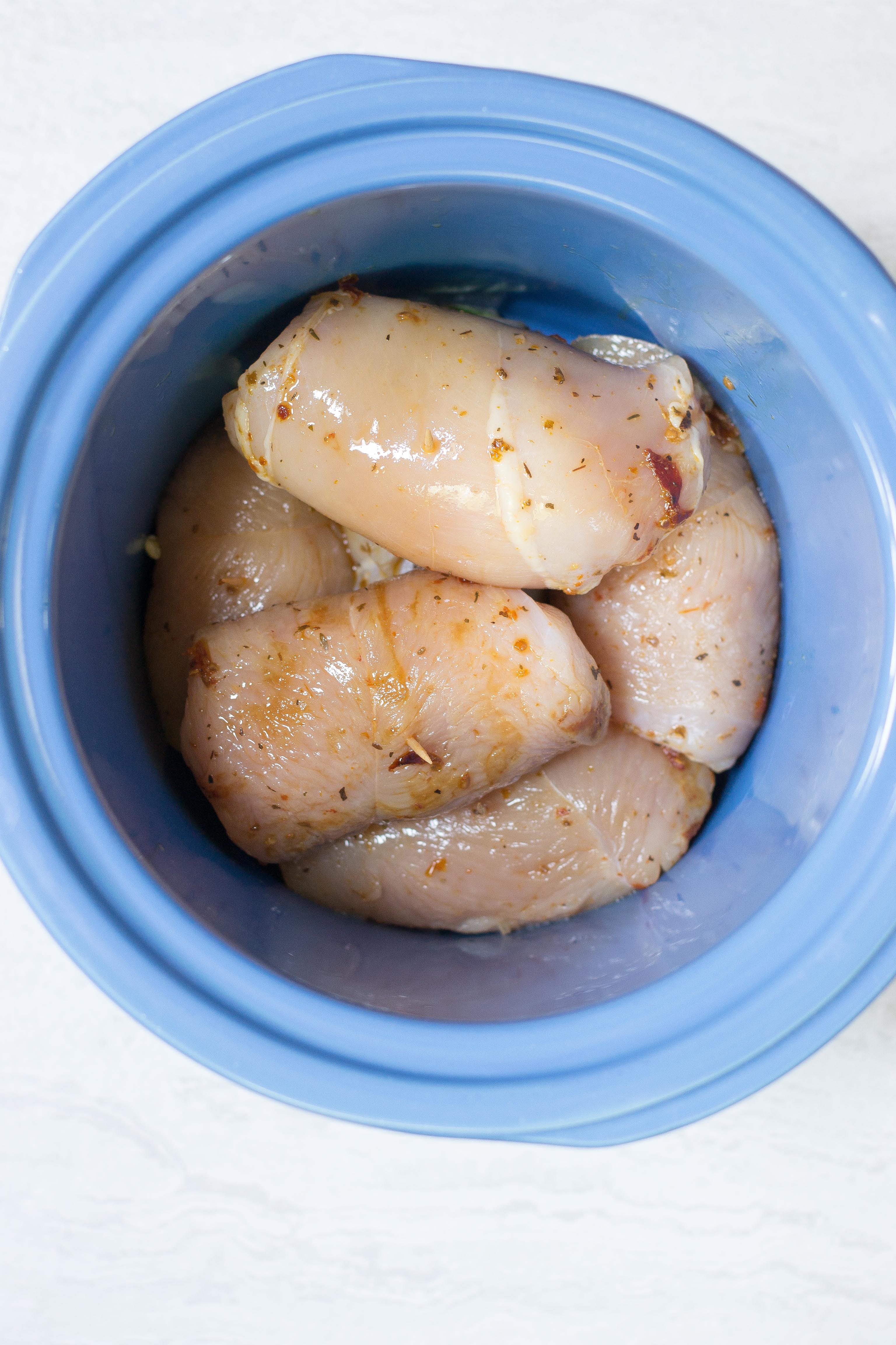 Slow Cooker Mozzarella Stuffed Chicken Breasts – Mozzarella stuffed chicken breasts are smothered with sun-dried tomatoes and artichoke hearts and slow cooked to perfection. Easy and delicious. A great meal for entertaining. Gluten-free. | QueenofMyKitchen.com