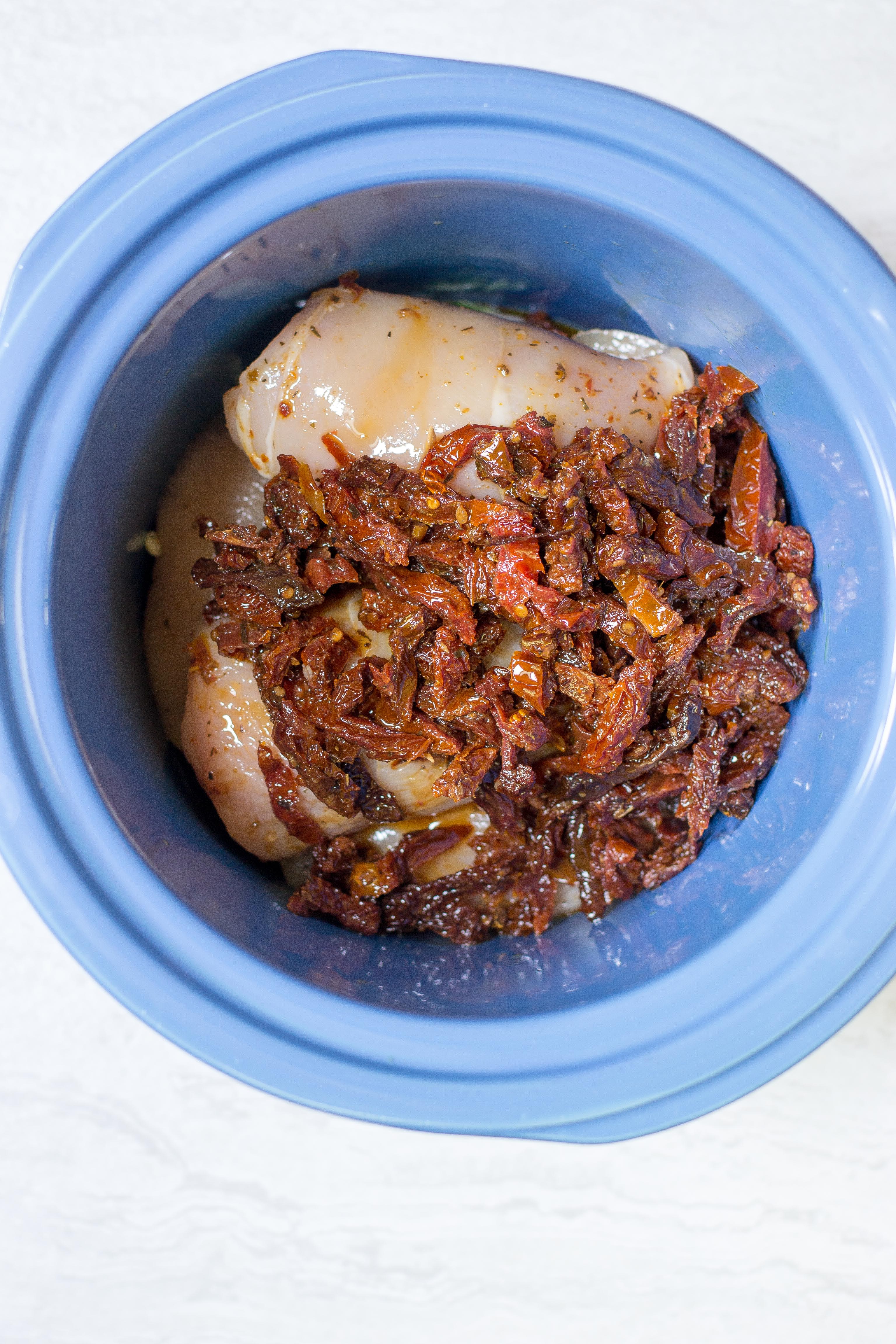 Slow Cooker Mozzarella Stuffed Chicken Breasts – Mozzarella stuffed chicken breasts are smothered with sun-dried tomatoes and artichoke hearts and slow cooked to perfection. Easy and delicious. A great meal for entertaining. Gluten-free. | QueenofMyKitchen.com