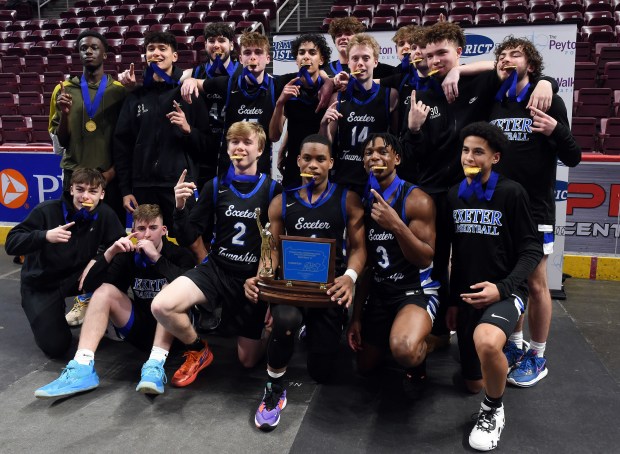 Exeter poses with its trophy after defeating Manheim Central in a District 3 Class 5A boys basketball game Thursday at the Giant Center. (BILL UHRICH - READING EAGLE)