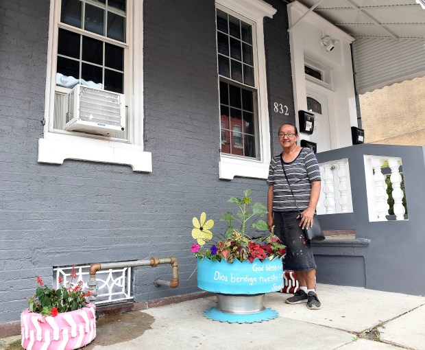Alicia Feblea stands outside her apartment with planters she had made to help brighten the 800 block of Chestnut Street. (BILL UHRICH - READING EAGLE)
