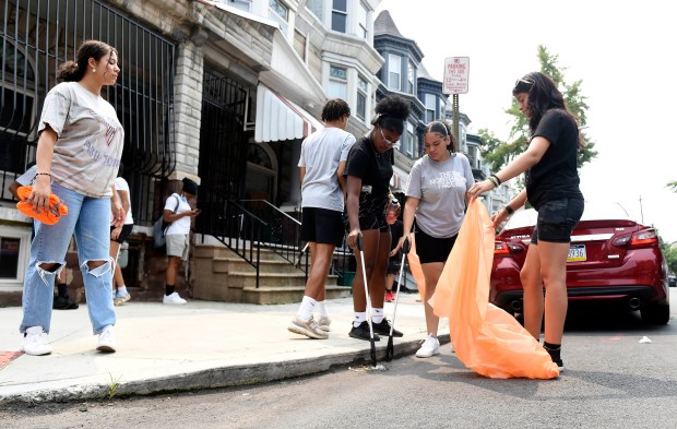 Interns with the city of Reading help with a cleanup in the 800 block of Chestnut Street. (BILL UHRICH - READING EAGLE)