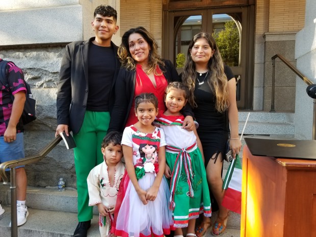 Alexis Frutos; his mother, Angelica Munoz Frutos; and sister, Victoria Frutos; celebrate Mexican Independence Day with Angelica's grandchildren, Ariel Frutos, Maricelia Milagros Frutos and Angiemarie Frutos; at a flag raising Friday outside City Hall. The Frutos family owns El Gallito Mexican Bakery, Grocery and Restaurant, 350 N. 10th St.MICHELLE LYNCH - READING EAGLE