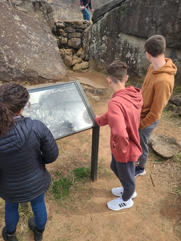 Three students at an explainer kiosk at Gettysburg Battlefield.