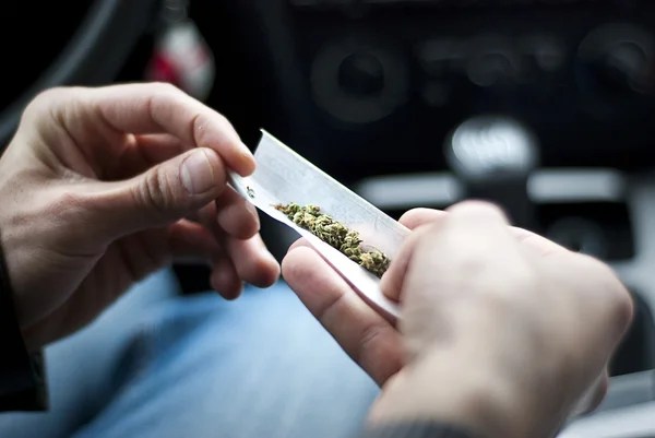 man making a joint with a cannabis rolling paper