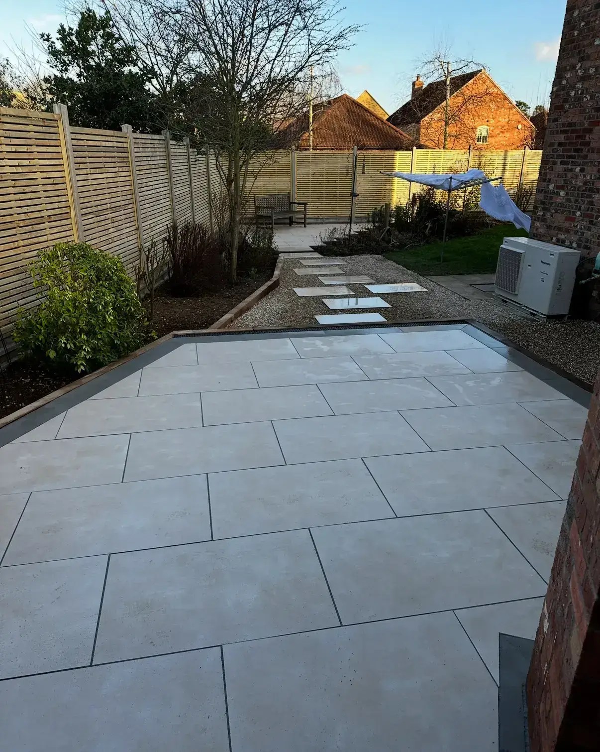 Modern porcelain patio in Gainsborough by Reshape Landscaping Ltd with light paving, gravel path and contemporary fencing