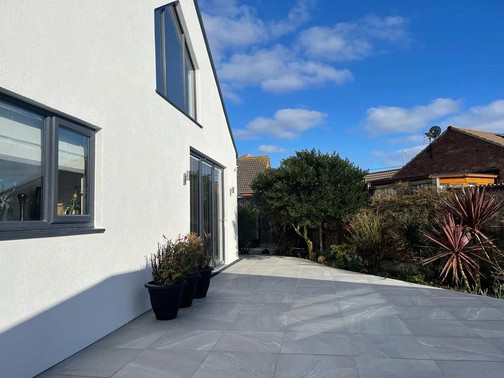 Patio installation in Lincoln with light grey porcelain tiles and modern garden layout
