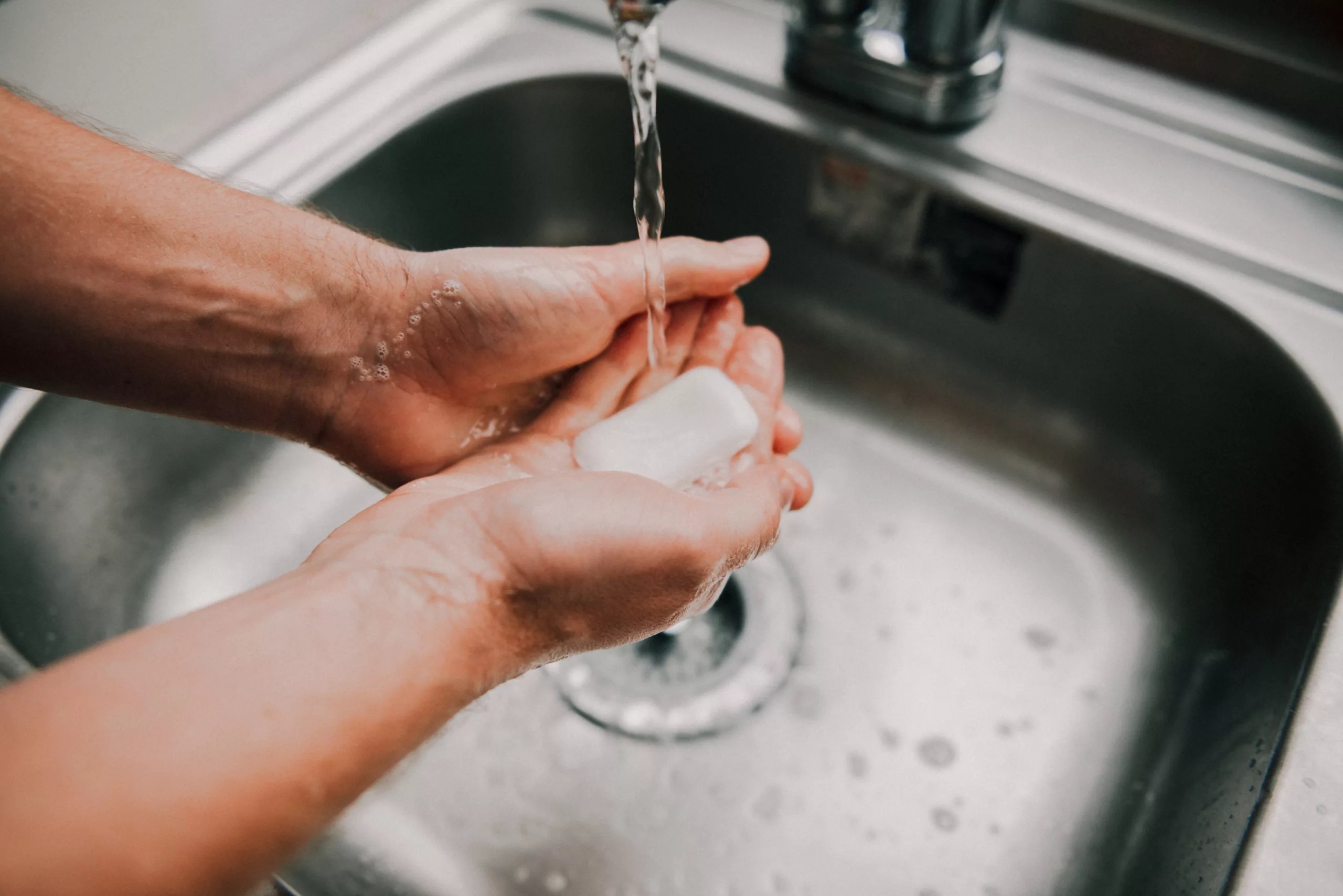 Se laver les mains avec du savon dans l'évier