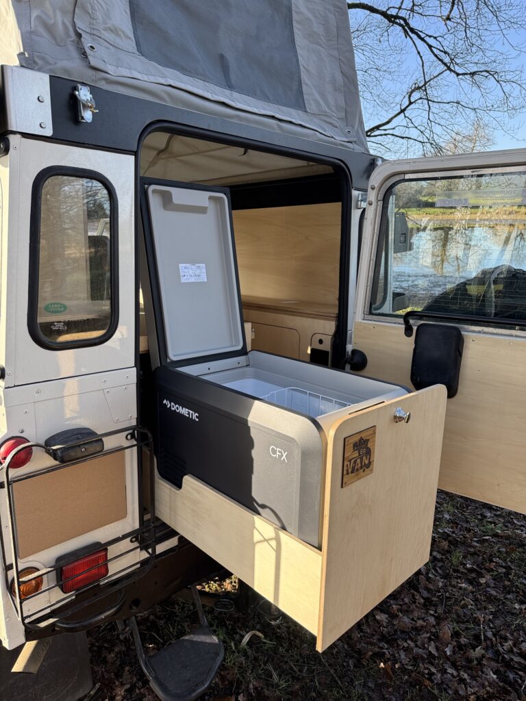 Land Rover Defender avec glacière à compression intégrée dans un tiroir accessible par le coffre