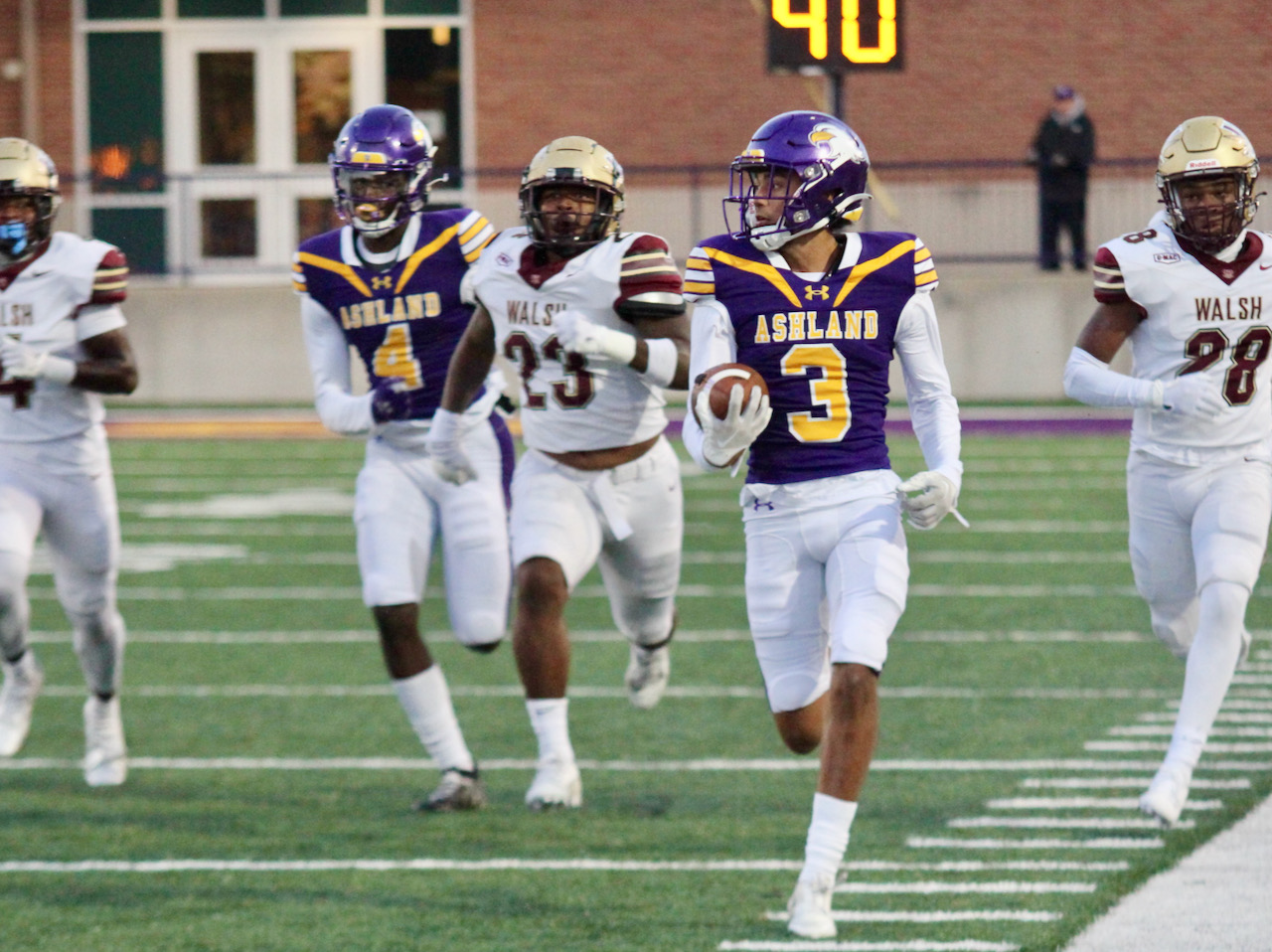 a football player runs with the ball