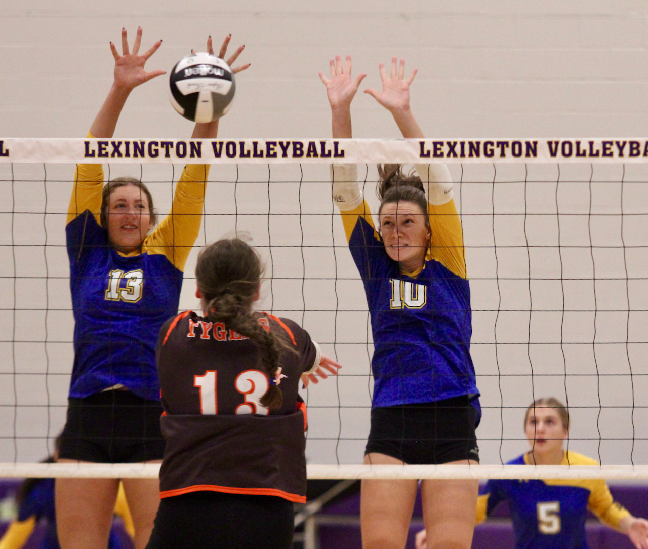 volleyball players block a shot