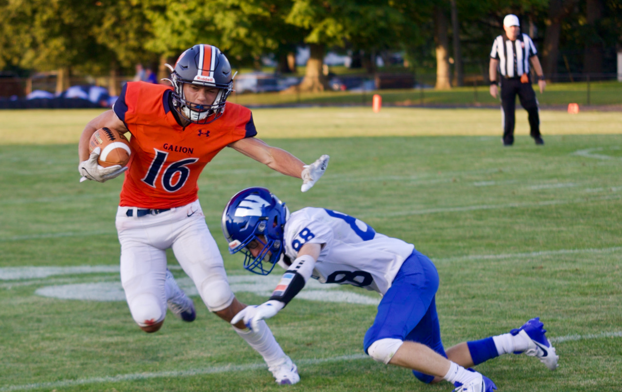 A football player tries to avoid a defender