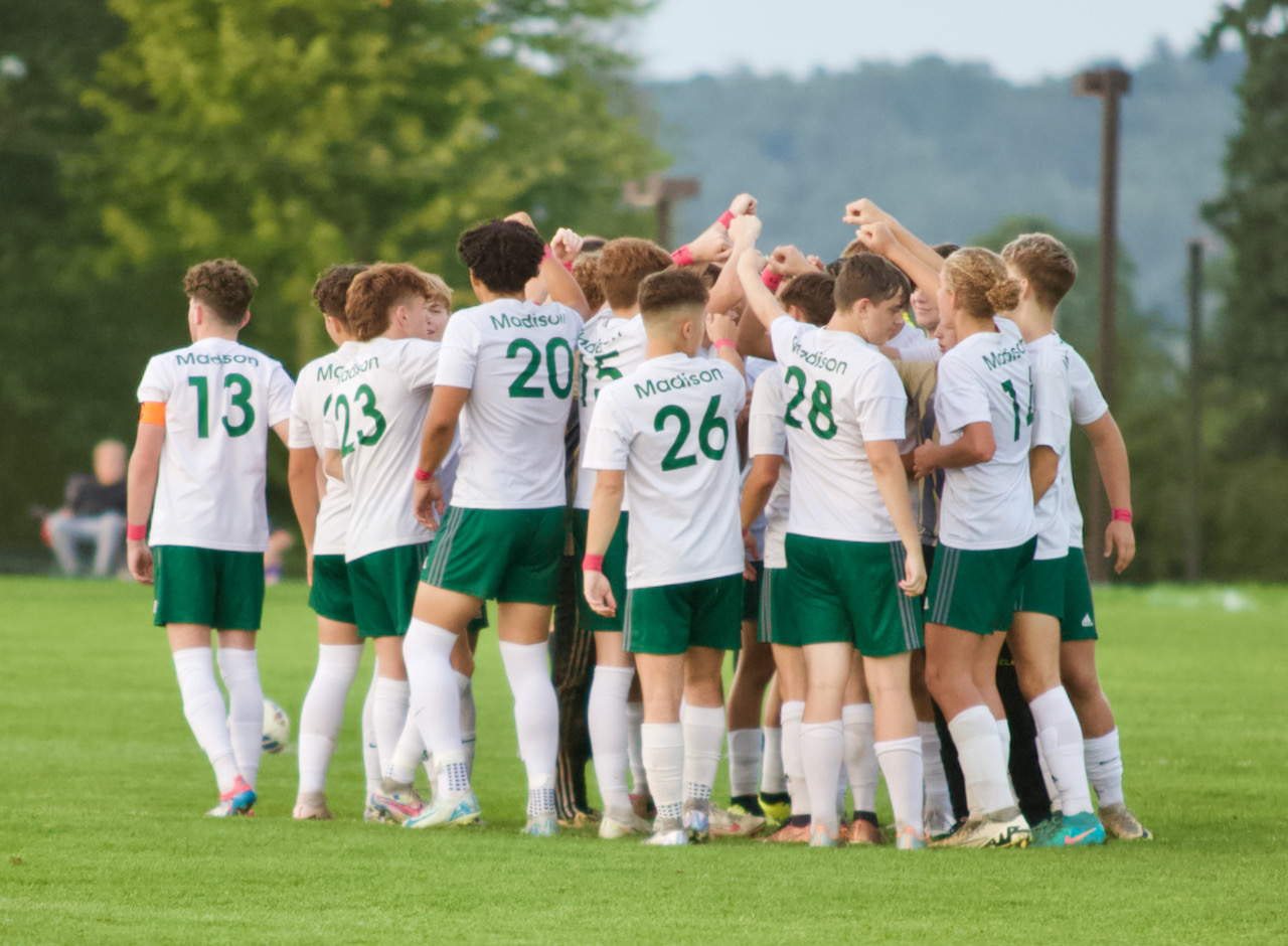 A soccer teams breaks its huddle before the start of a match
