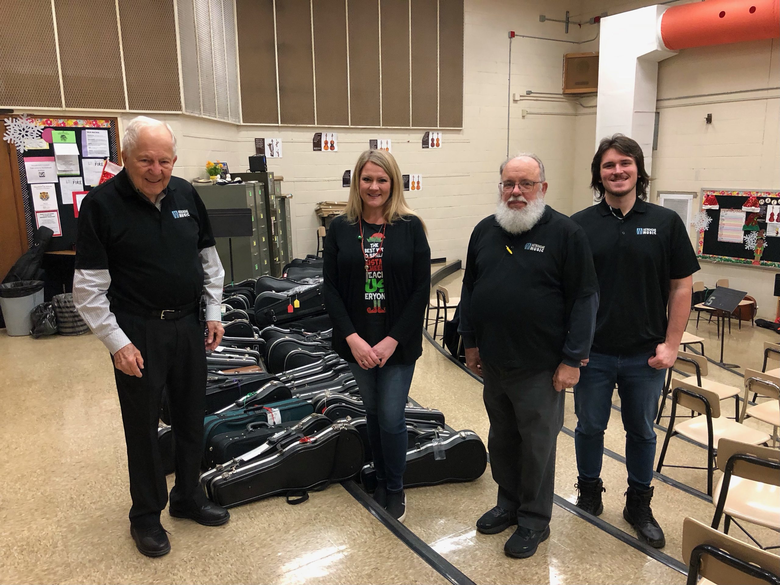 four people pose for a photo in the Malabar Intermediate band room