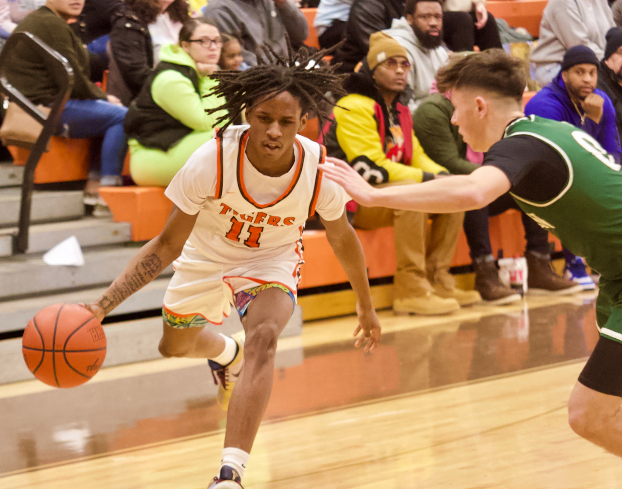 A basketball player drives past a defender
