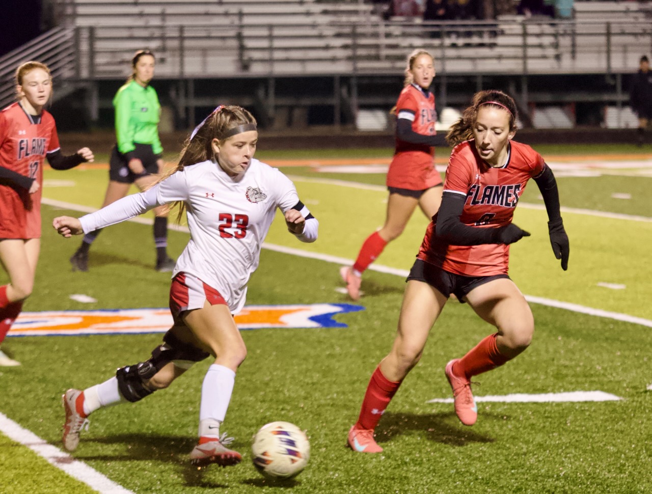 a soccer player dribbles the ball past a defender