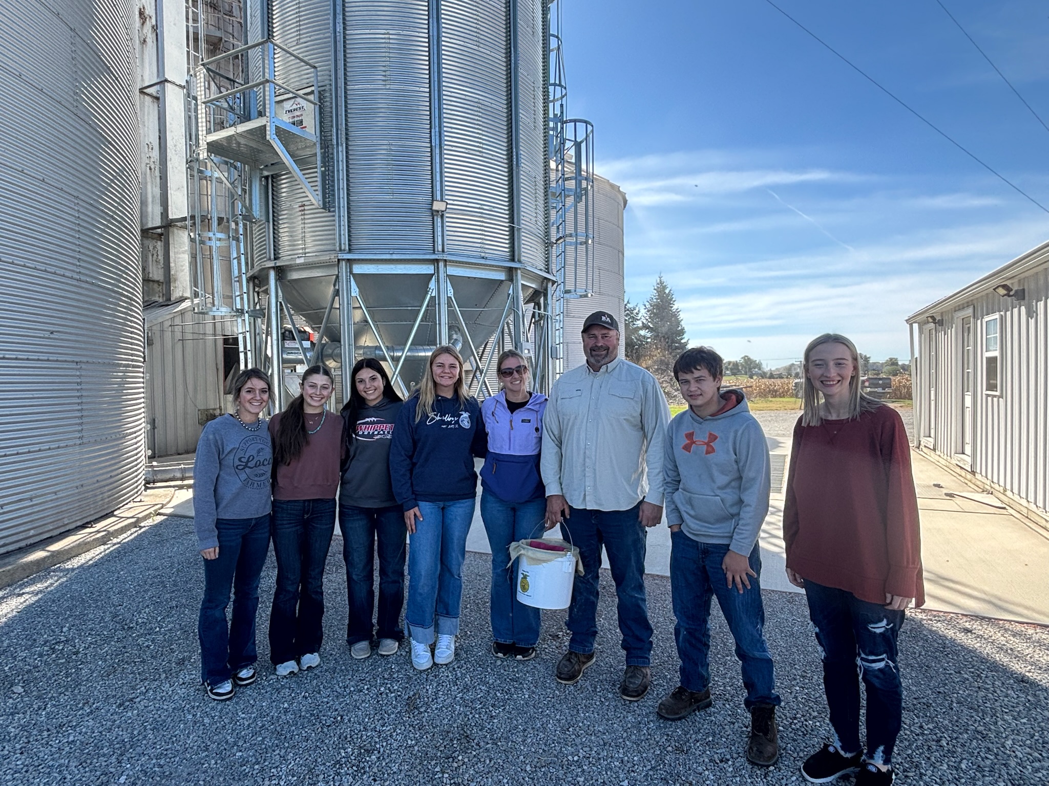 high school students standing with farmer