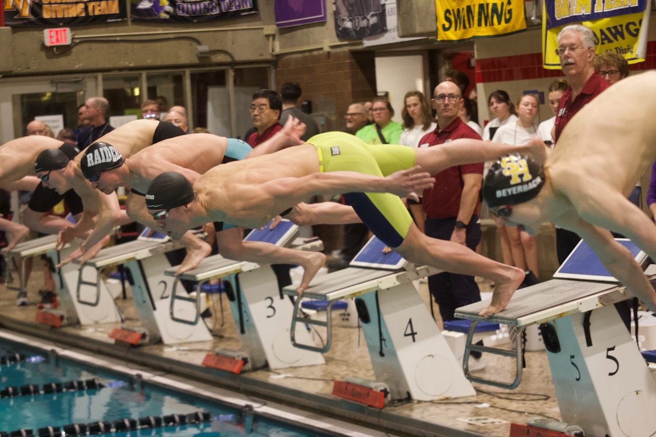 a swimmer dives into the pool