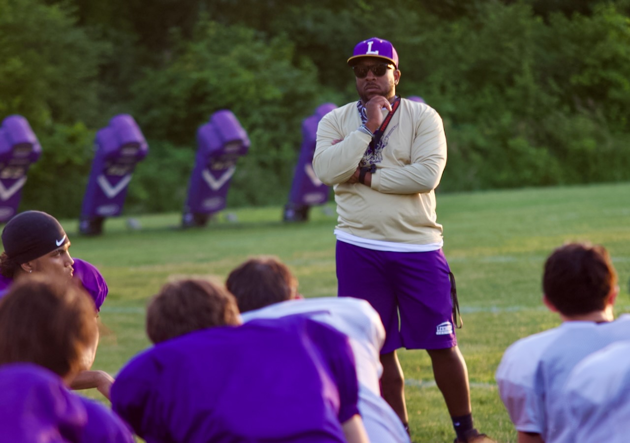 a football coach addresses his team after practice