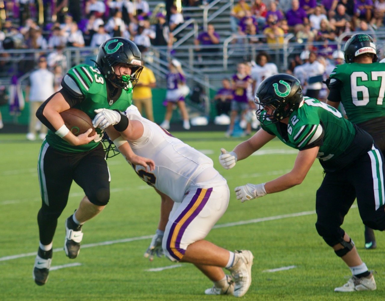 a football player runs through an arm tackle