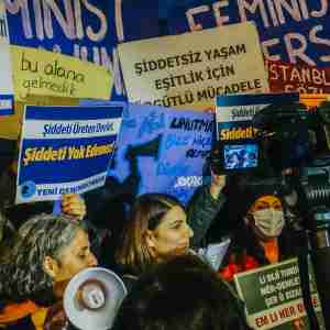 Surrounded by placards and feminist activists, a woman delivers a speech during the International Day Against Violence Against Women on 25 November in Kizilay